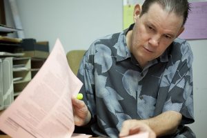 Rob in a Hawaiian shirt reviewing paperwork at the office