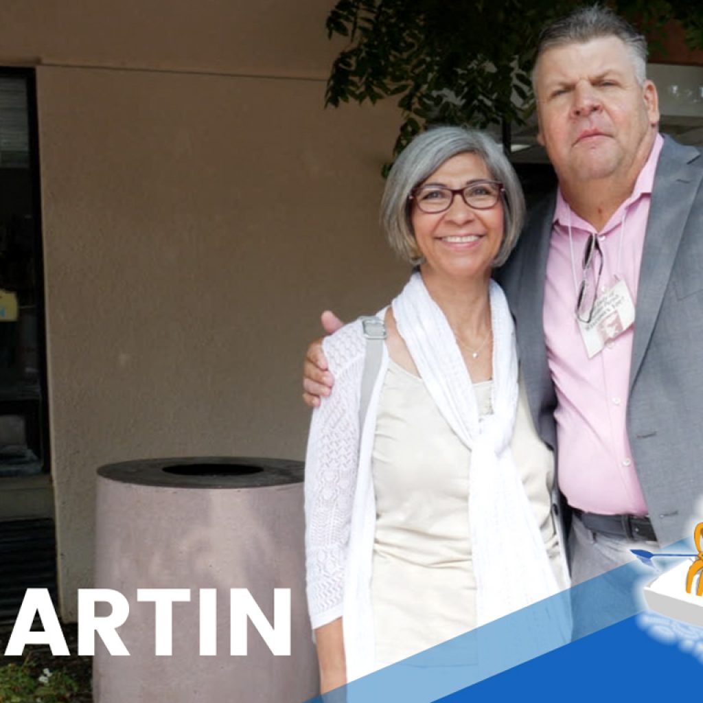 Martin and an older woman in a white dress posing together in front of his church