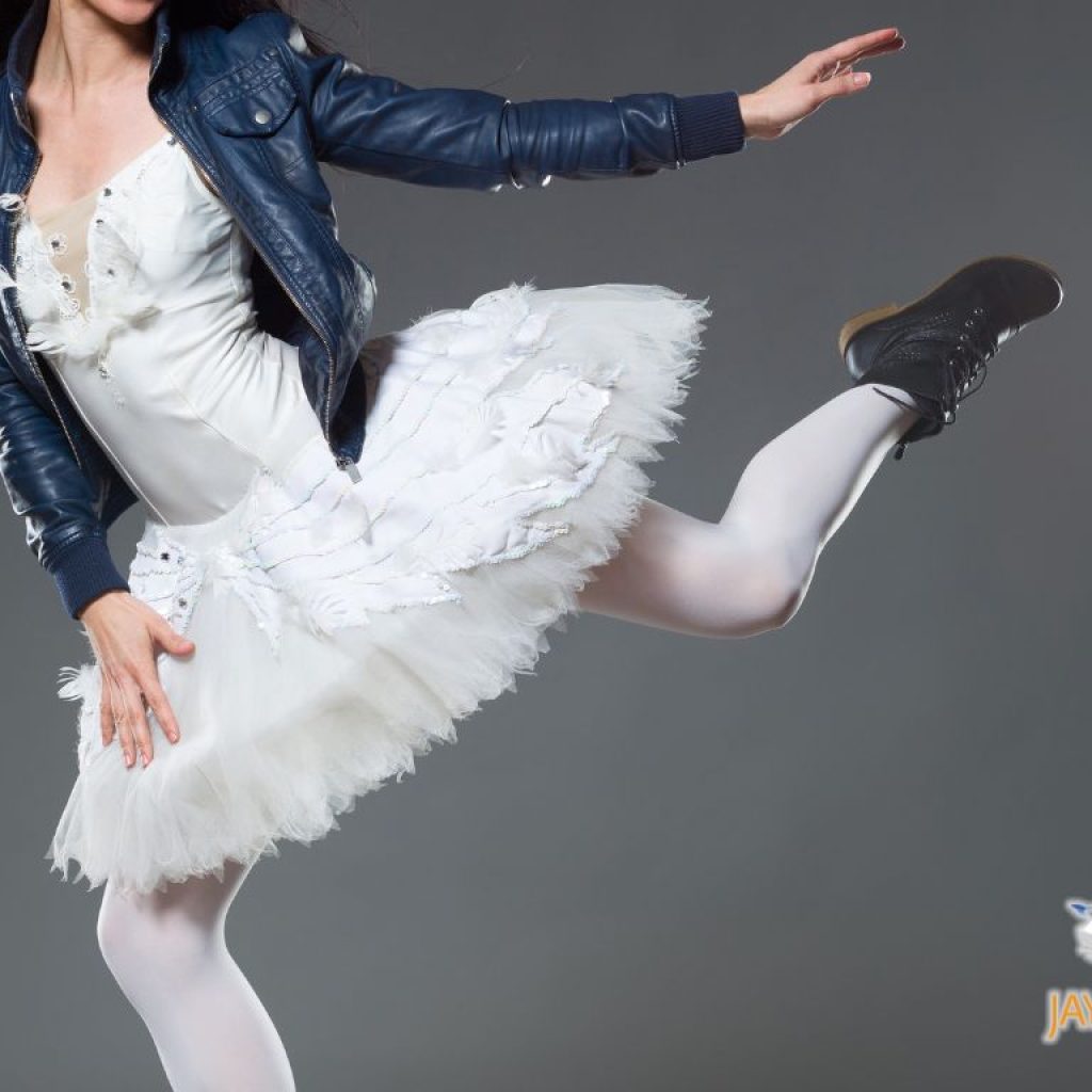 Ballerina in a white tutu and a leather jacket and leather boots