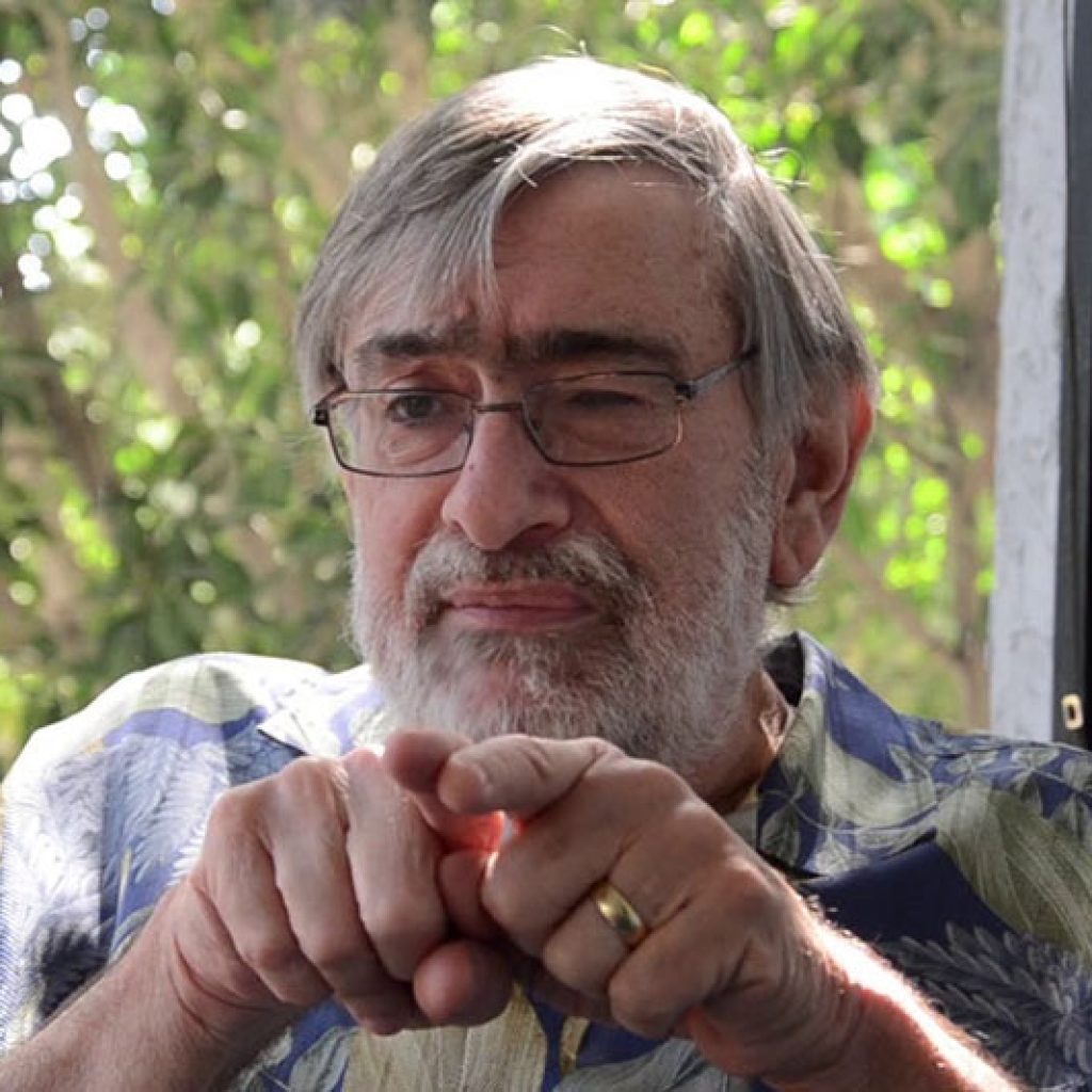 Former JNCS Executive Director explaining something next to a window