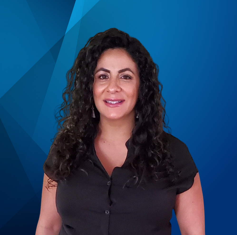 A portrait of a woman with curly hair smiling, against a blue geometric background.