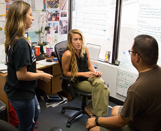 Three JNCS staff discussing something in an office