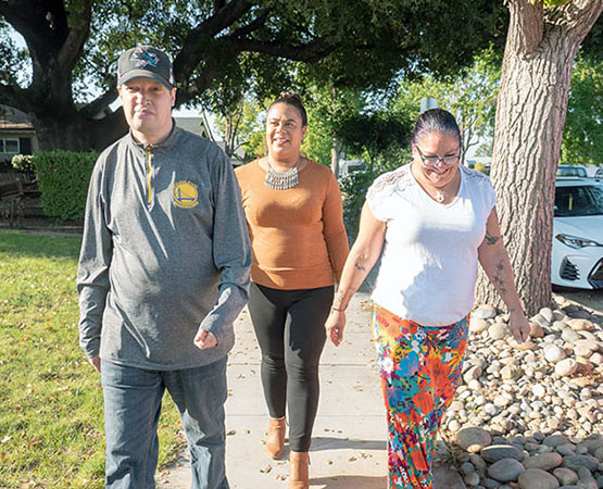 Two JNCS staff and supported individual taking a walk down the sidewalk