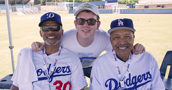 Supported Individual (center) posing with two Dodgers players