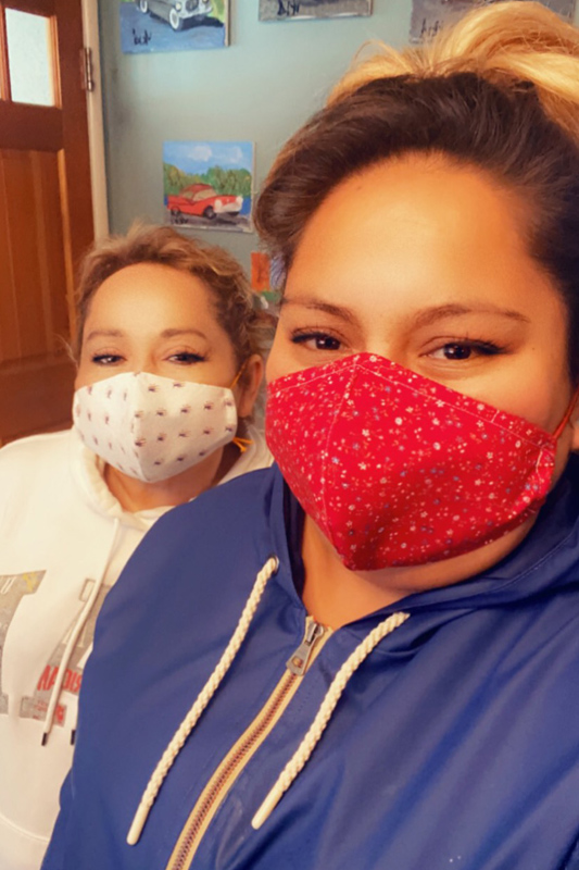Two women wearing facemasks looking at the camera