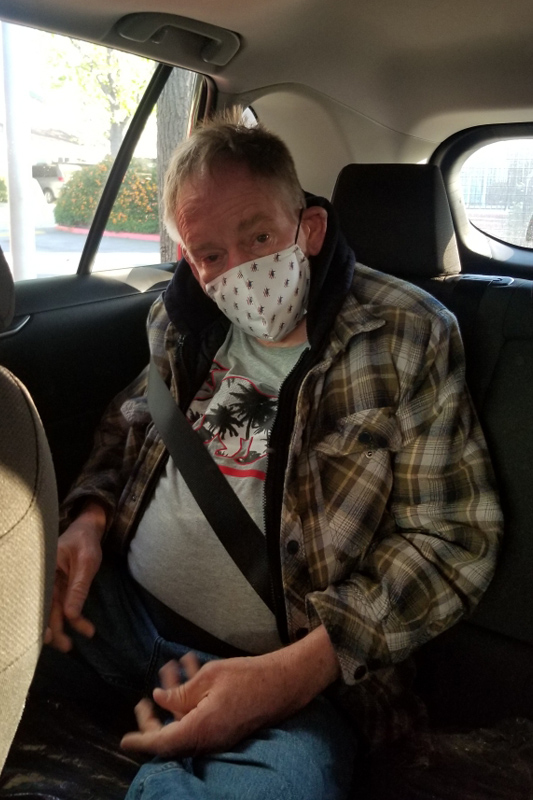 Man wearing a facemask sitting in a car