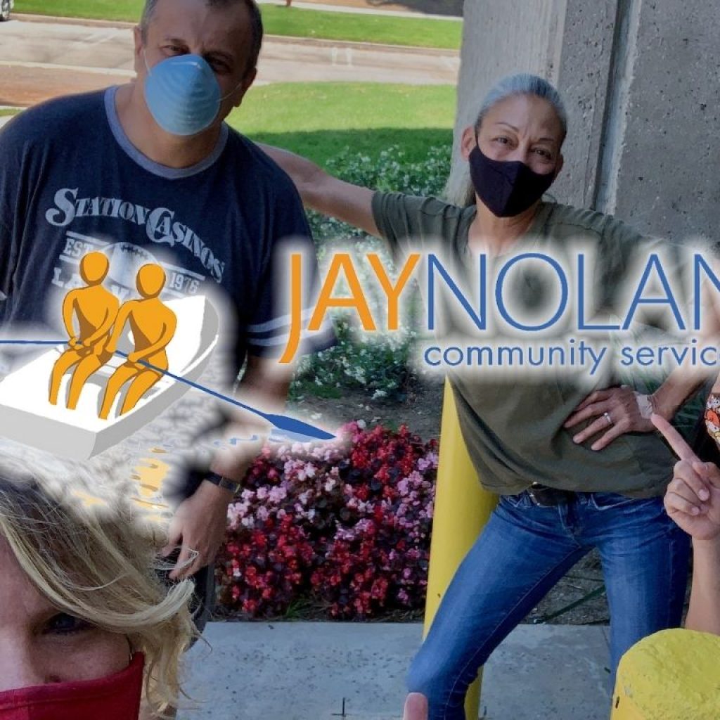 Group of four people wearing face masks posing for a group photo at a park with JNCS logo overlaid
