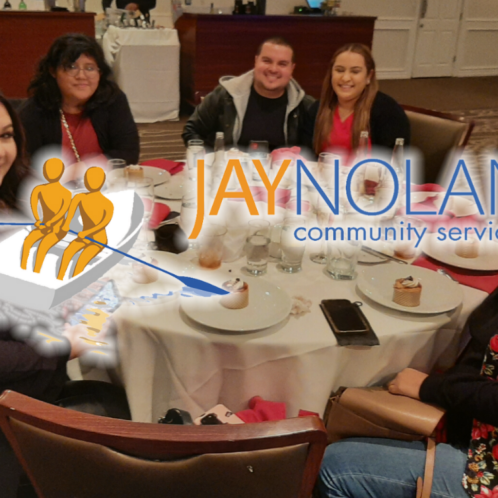 Six people sitting around a holiday table with the JNCS logo overlaid