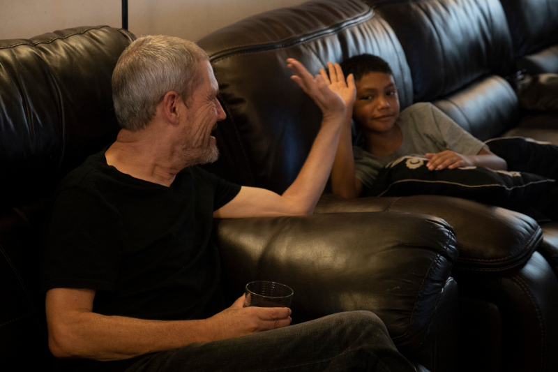 Rob and a young boy high fiving each other while sitting on a couch