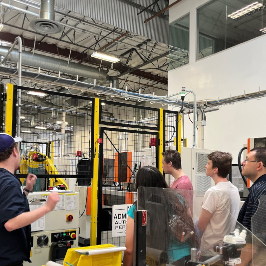 Students at the Uniquely Abled Academy (UAA) getting a tour of a CNC machine workshop