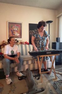 Ilene plays the piano while Marisol sits next to her