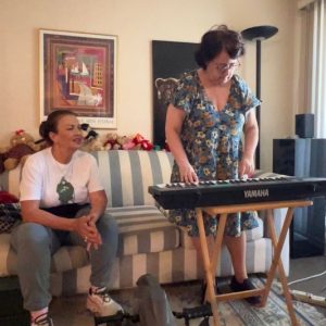 Ilene plays the piano while Marisol sits next to her