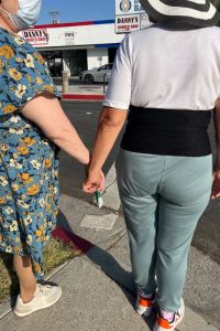 Ilene holds Marisol's hand before crossing the street