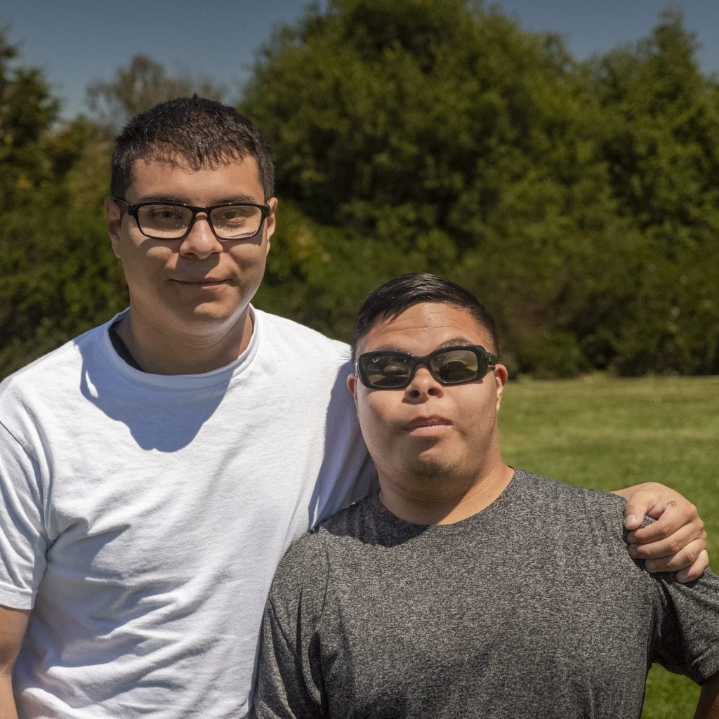 photo of two brothers side hugging.