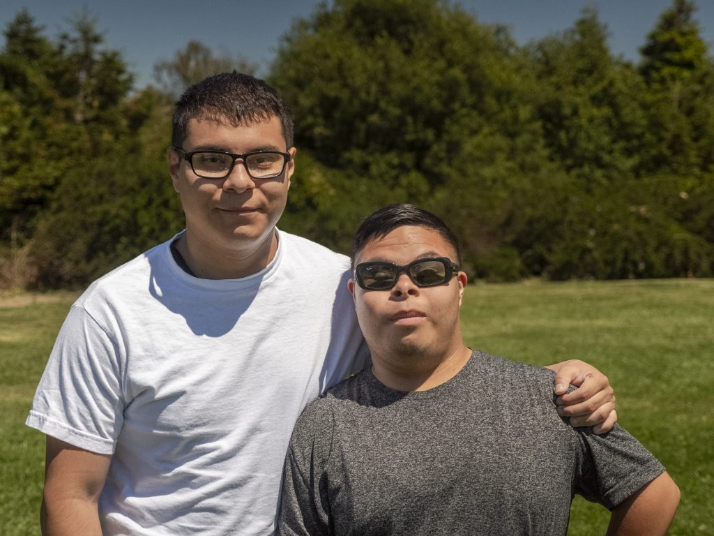 photo of two brothers side hugging.