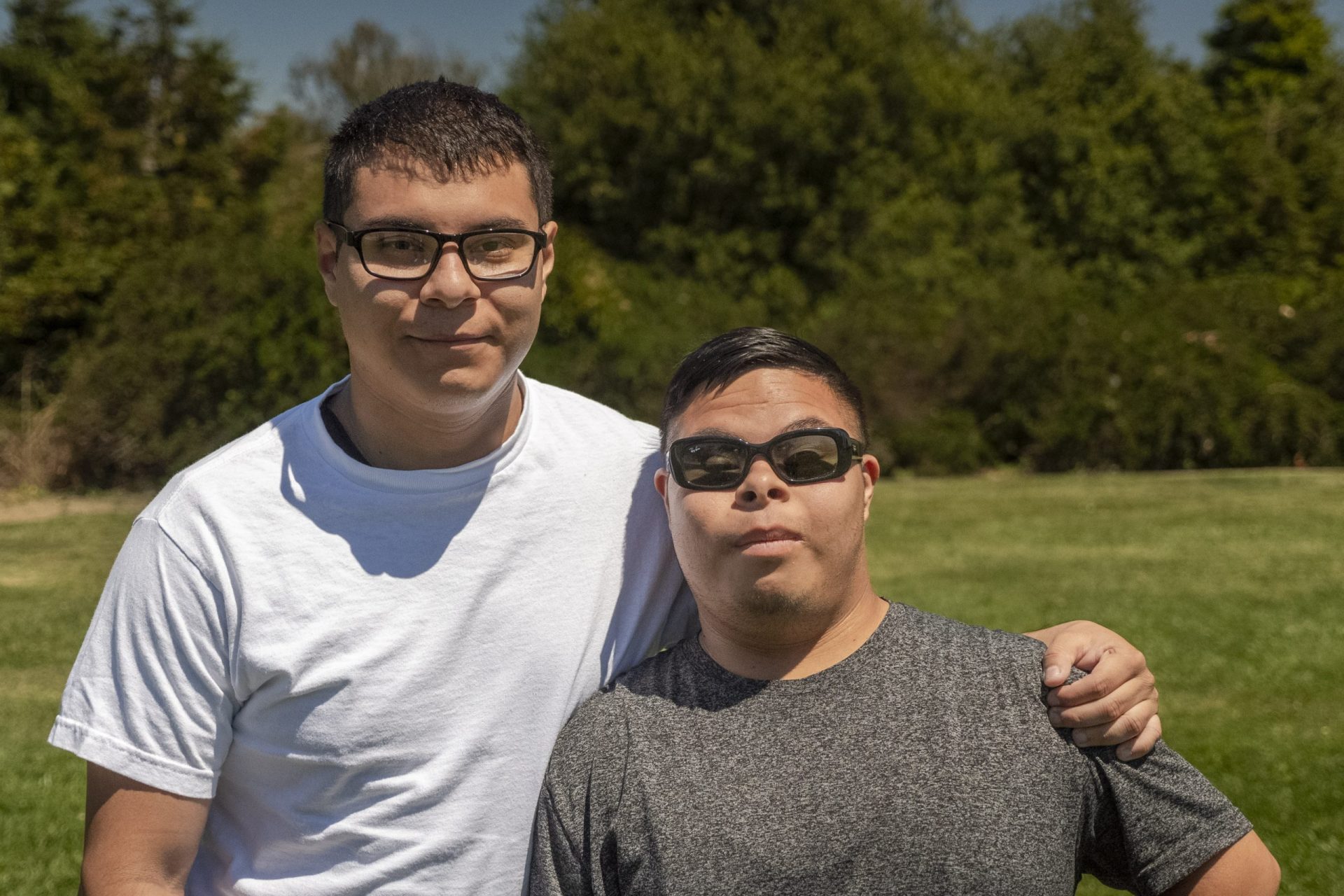 photo of two brothers side hugging.