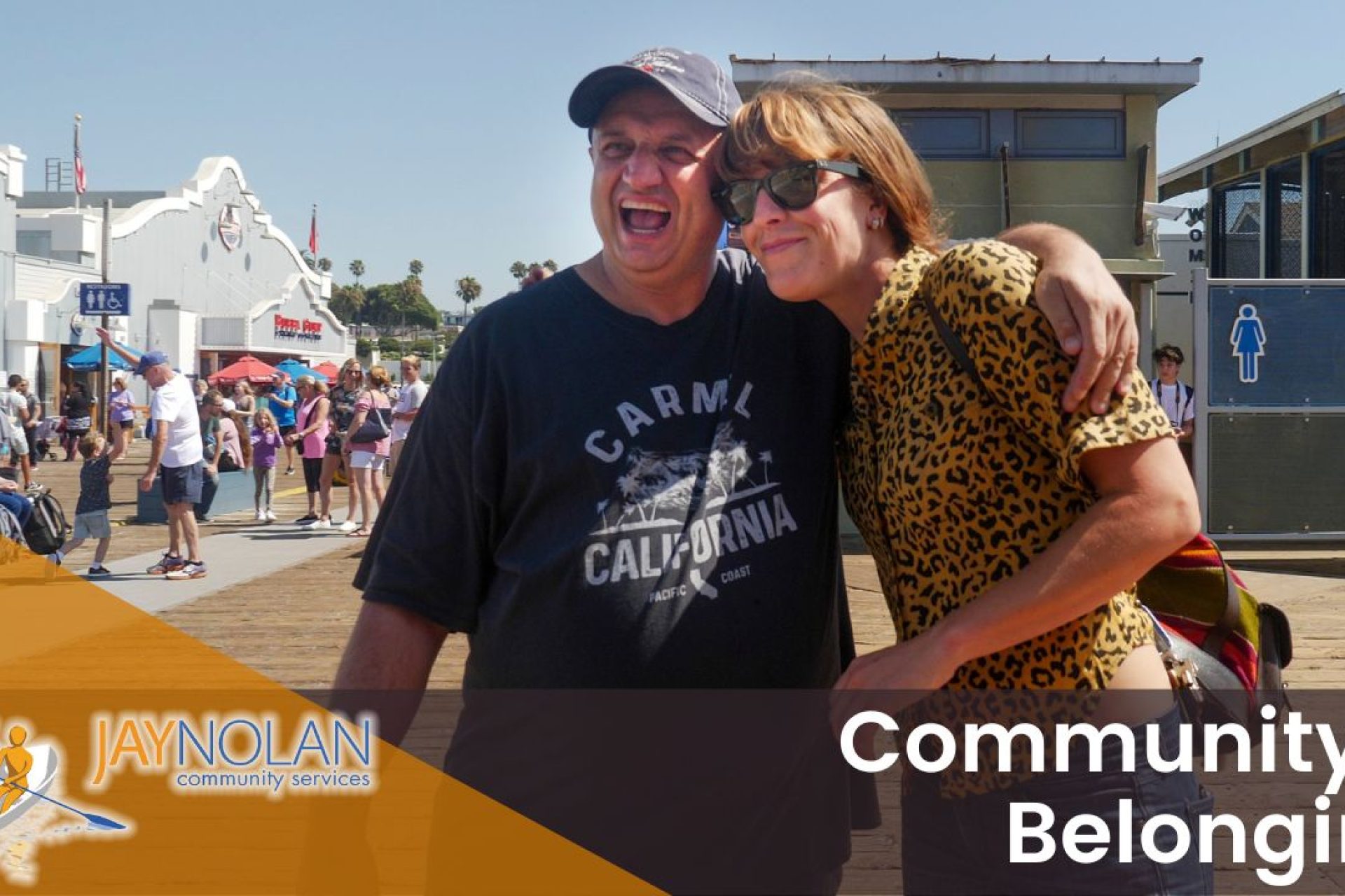 Video Thumbnail featuring a Caucasian man and woman in a sideways hug at the Santa Monica pier. Text reads: "Community & Belonging"