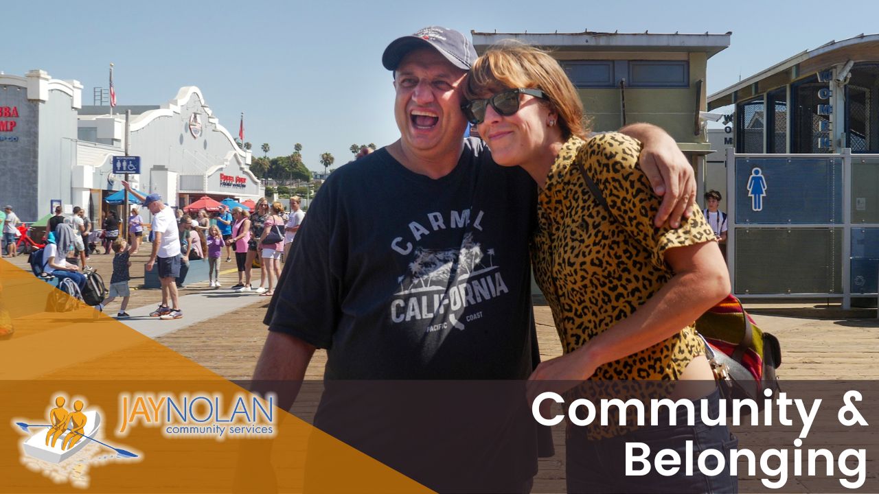 2024-video-thumbnails Video Thumbnail featuring a Caucasian man and woman in a sideways hug at the Santa Monica pier. Text reads: "Community & Belonging"