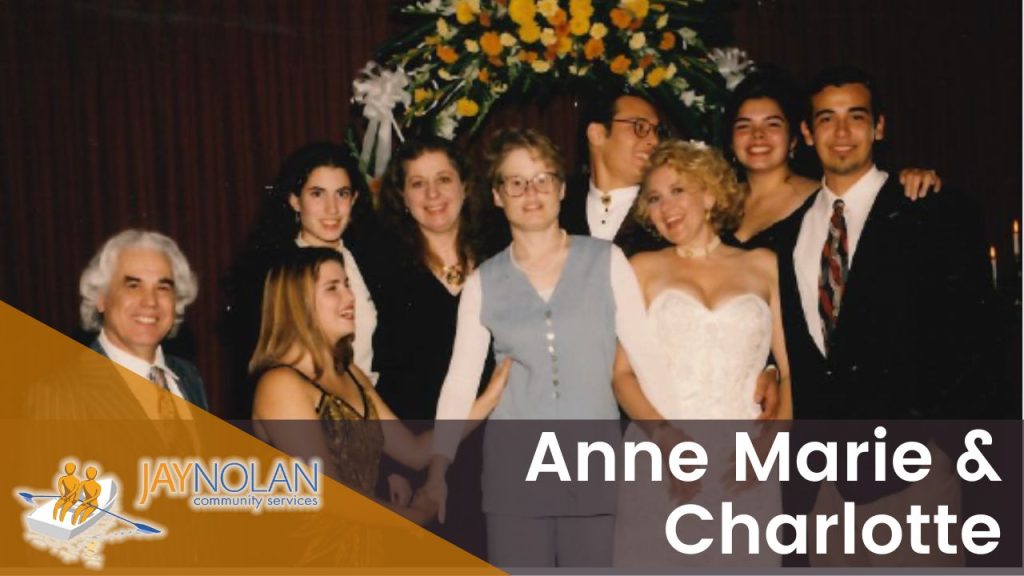 Video Thumbnail featuring a vintage wedding photo of a bride and groom posing with their guests under and flower arch at night. Text reads: "Anne Marie & Charlotte"