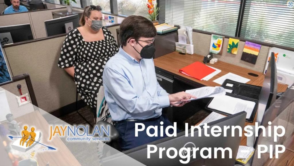 Video Thumbnail of two people sitting in an office cubicale: a young man in a light blue button down shirt and a woman in a black and white polka dot dress. Text reads: "Paid Internship Program (PIP)"
