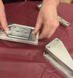 metal parts created by a CNC machine sitting on a table with a red tablecloth