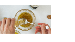image of two hands mixing ingredients for homemade salad dressing.