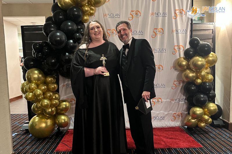 Jay Nolan Manager Micaylah Stewart posing with the Jay Nolan CEO while holding a Key Results Award trophy.