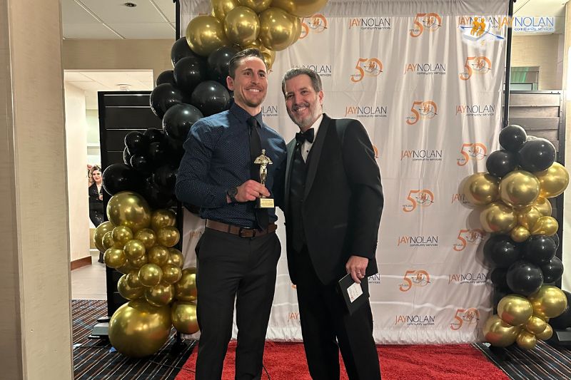 Jay Nolan Manager Sean McCormack posing with the Jay Nolan CEO while holding a Key Results Award trophy.