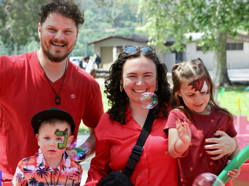 Family with two kids all wearing red to celebrate Autism Acceptance Month.
