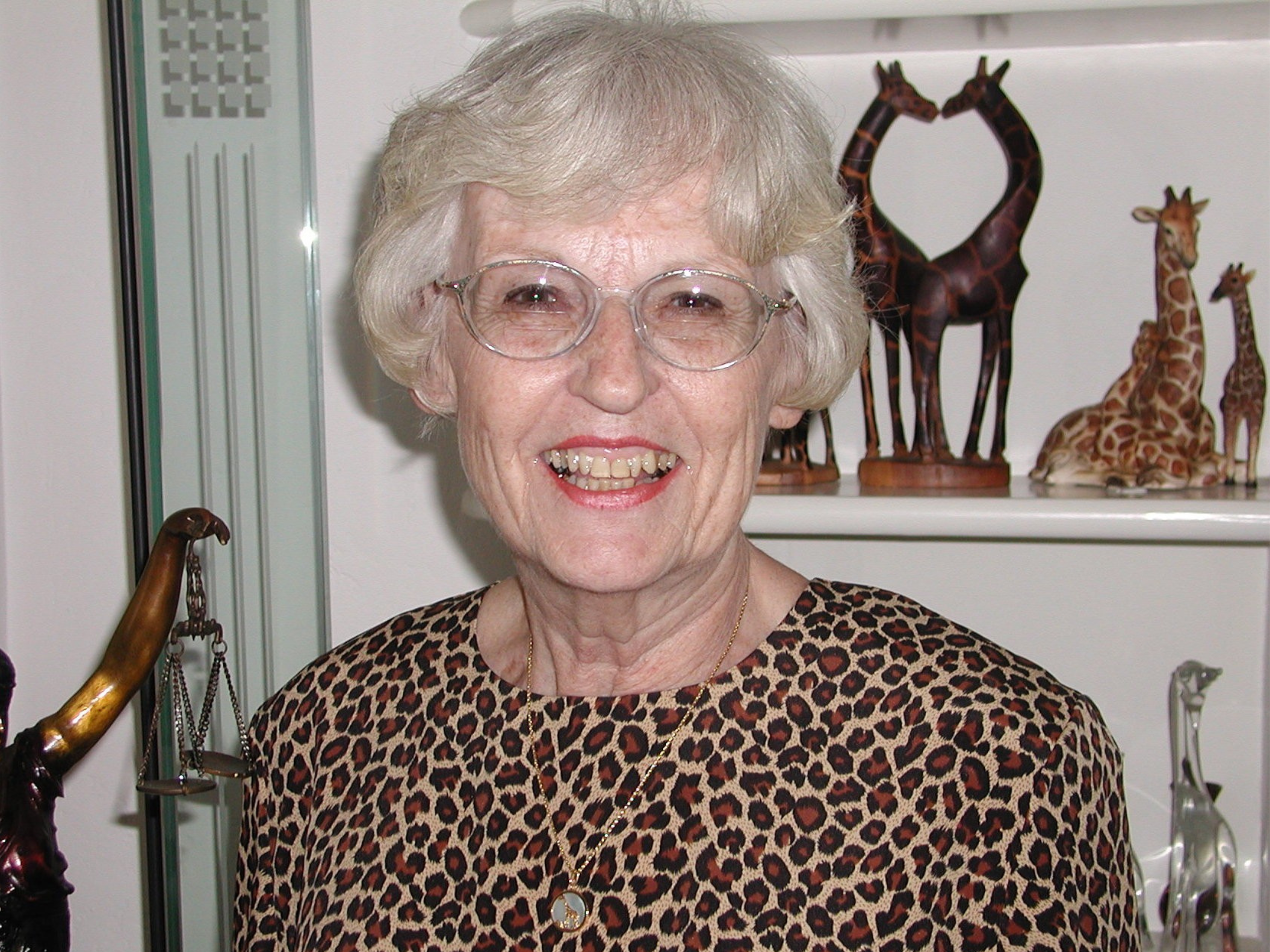Portrait of Toby Arenberg: A smiling Caucasian woman with short curly white hair.