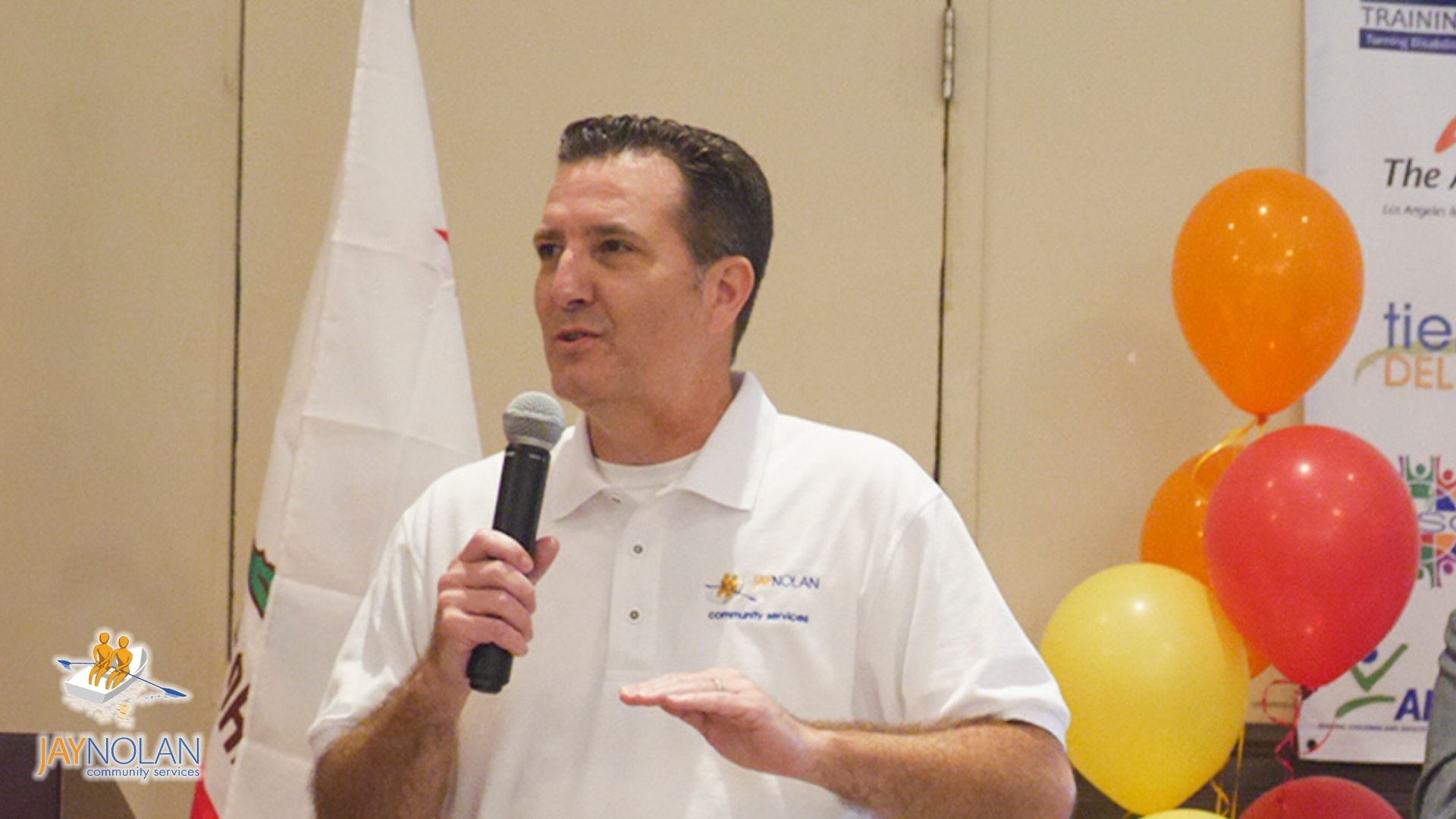CEO Edward Amey with a mic in hand doing a speech at a community event